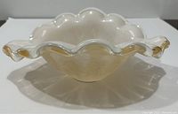 Front angled view showing the ruffled edge and translucent amber coloring blended with white glass.