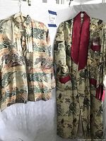 Front view of the jacket and robe hanging next to each other on hangers.
