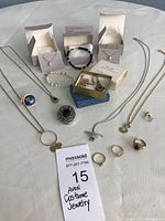 Full display of Avon costume jewelry including rings, bracelets, necklaces, and boxed items on white surface