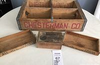 Photo showing one large Chesterman Co wooden crate with metal reinforcements, two Abbots cream cheese wooden boxes, and one Cloverdale codfish box placed on white table