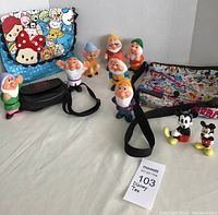 Shows all seven dwarf figurines, two Mickey Mouse figurines, and three Disney character print bags including one Michael Kors bag in the lot.