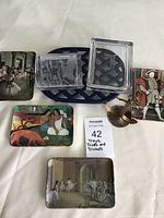 Group photo showing all trays, trivet, glass trinket boxes, and brass anchor trinket together on a surface.