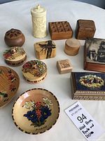 assortment of wood boxes, a bowl and a dish with various designs including floral and carved patterns, one tall carved cylindrical box, one round box with painted flowers, several rectangular and square boxes some with illustrations