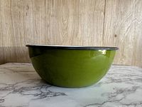 Side view of large green enamel mixing bowl showing smooth shiny surface and black rim