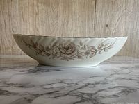 Side view showing floral design wrapping around the serving bowl with beige base and brown rose motifs.