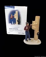 Front view of the Jonathan The Bear Man figurine with box showing man painting bear on tree trunk