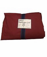 Folded red organic cotton duvet cover with navy ribbon and product SKU tag showing color red and size twin.