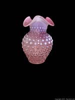 Front angle photo of pink hobnail glass vase with ruffle edge showing texture and color.