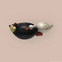 Front and side views of vintage Goebel Hummel ceramic ashtray showing white duck and yellow bird detail on black base.