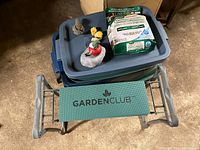 Overview photo of the gardening stool with Garden Club logo, garden storage bins, gnomes, garden stone, and bag of garden soil on top of bins.