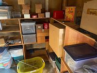 Multiple wooden shelves filled with plastic storage bins, cardboard boxes, and a yellow plastic basket
