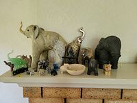 View of entire lot on white mantel showing all figurines with varying styles and colors.