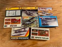 Full lot of seven vintage model airplane kits displayed on wooden floor, showing box art and variety of aircraft models including Nieuport, Spad, Avro, Westland, Fairey, Hawker, and Sopwith