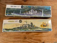 Both model kit boxes for HMS Hood and Bismarck showing illustrated box art and Airfix branding.