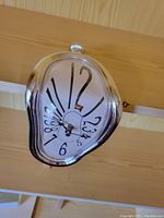 Overall view of the novelty clock showing the melting warped shape and distorted numbers.