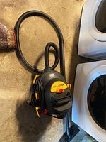 Full view of the Shop-Vac including hose and cleaning tube on floor.