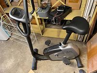 Full side view of the Trio stationary bike showing frame, seat, pedals, handlebar and base.