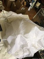 White crinoline with poofy fullness on a table, showing overall fabric and lace trim