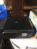 Full view of the black HP Photosmart C4780 printer showing top and front sides on a black table surface