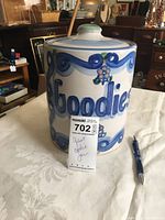 Front view of the large ceramic cookie jar showing the word 'Goodies' in blue lettering with floral decoration and lid with round handle.
