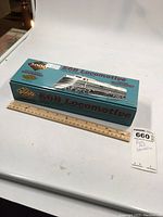 Boxed HO scale E6B locomotive model with a ruler for size reference.