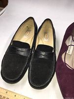 Pair of black Talbots suede penny loafers size 7.5 shown on white background with ruler for scale.