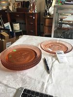 View of two pink Depression glass plates on a white cloth, showing overall shape, design, and color.