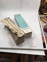 Photo showing Walther model railroad kit box with blue and white stripes, open box with paper wrapping inside and additional small parts boxed separately.