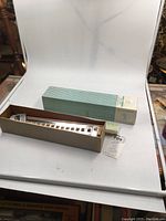 Coach car model kit in opened original box with green and white stripes, along with box corner and tag showing brand and kit number.