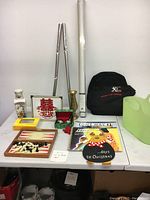 Photo of multiple household items including games, decor, books, and accessories arranged on table