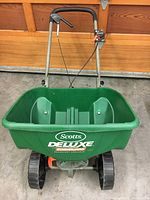 Frontal image of the spreader showing the hopper opening and wheels for overall shape and size.