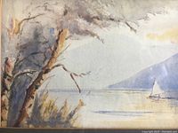 Close-up image of watercolor painting showing tree, lake, sailboat and mountain scene with signature.