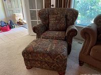 Front view of armchair and ottoman showing the detailed multicolor pattern fabric and shape of the items.