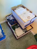 Box of assorted crafting fabric including white, blue, cream, and green fabrics with various patterns