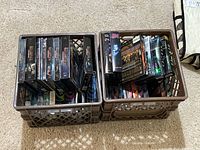 Two plastic crates filled with DVD cases showing multiple sci-fi TV series including Battlestar Galactica and Stargate Atlantis.