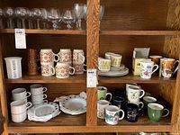 Full shelf with array of mugs and plates showing variety in styles, colors and patterns
