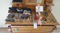Full lot overview laid out on wooden dresser showing glasses, watches, jewelry, box, buttons, and crayons