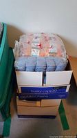 Two stacked copy paper boxes containing several packaged yarn types