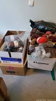 Boxes with assorted yarn skeins, some unopened, various colors and neutral tones