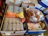 Two cardboard boxes containing multiple yarn skeins and bundles in various colors