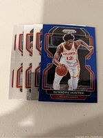 Six Atlanta Hawks basketball trading cards featuring De'Andre Hunter, with blue bordered modern design and Panini Prizm branding.