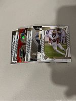 Photo of 8 New Orleans Saints NFL trading cards stacked and fanned out on flat surface showing a variety of card designs and players.