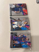 Three Topps Finest soccer cards in plastic sleeves: Lionel Messi, Dejan Kulusevski in Juventus, Neymar Jr. in FC Barcelona kit