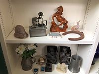 Shelf display with horse figurines, horseshoe, metal decor, and pewter mug.