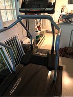 Full view of the StarTrac Sport treadmill showing black and gray color scheme, handrails, and StarTrac branding on the belt.