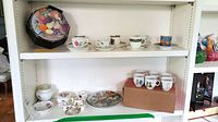 Shelf with Gein French Fruit plates, tea cups and saucers, miniature Coalport tea set, and some boxed cups