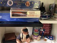 Full view of shelves showing puzzles on top and Cubs collectibles including bear mascot, gumball machine, baseball glove figurine on lower shelf