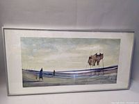 Framed painting showing two figures and elevated structure in muted landscape colors.