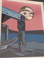 Close-up photo of the print showing wooden post with carvings and moon in background, with pink and blue color palette.