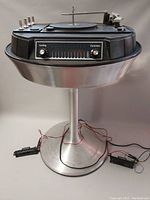 Front view showing tuning and function knobs and pedestal base